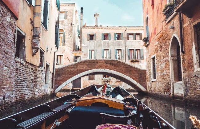 Gondola point of view in front of a bridge on canal in Venice, Italy