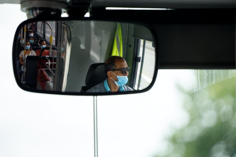 People in a bus wearing masks