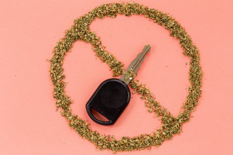 A car key in a circle with a line through it composed of dried cannabis.