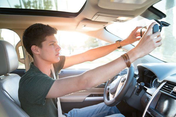 Teenage boy adjusting rear view mirror