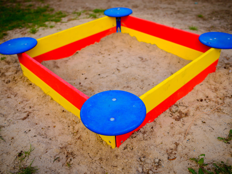 Sandbox playground surrounded by green grass