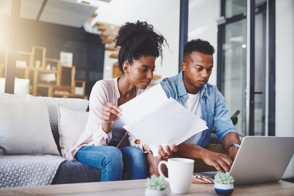 Couple on couch with papers and laptop