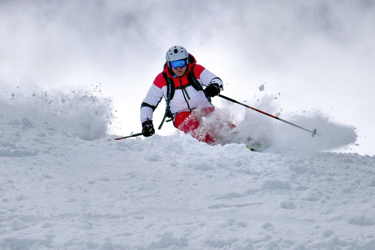 Skieer going through snow in pila, aosta valley, italy