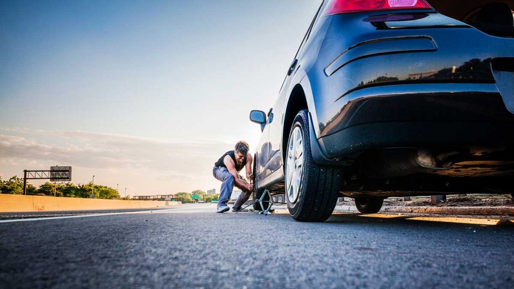 What is Road Hazard Protection - Man changing flat tire
