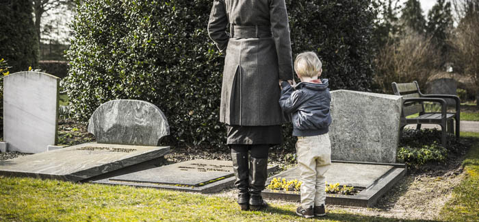 mother standing at grave with her son for Quotacy blog dealing with grief