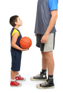 Little boy asking big man to play basketball