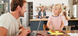 dad with toddler and wife and daughter in background for Quotacy blog easiest way to get life insurance