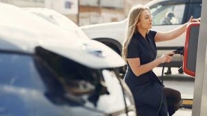 Buying an Electric Car Benefits and Tips - Woman at electric car charging station