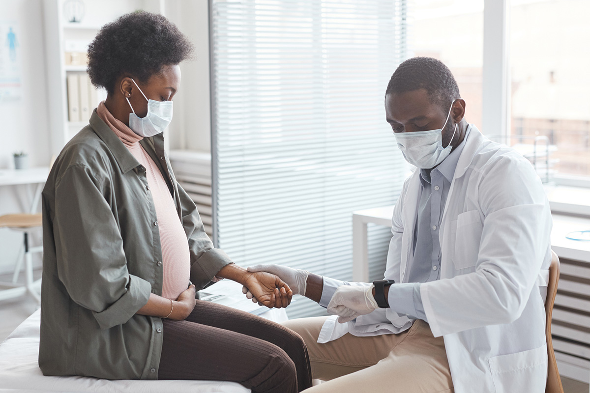 Doctor measuring the pulse of pregnant woman