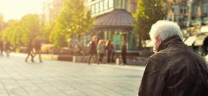 Image of elderly man sitting on bench downtown in a city for Quotacy blog Is Guaranteed Issue Life Insurance a Good Option?