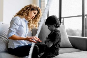 Boy having a tantrum at home and mother trying to talk to him