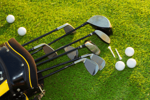 Golf clubs and balls neatly laid on lawn