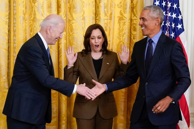 Vice President Kamala Harris reacts as President Joe Biden shakes hands with former President Barack Obama after Obama jokingly called Biden vice president in the East Room of the White House in Washington, Tuesday, April 5, 2022.