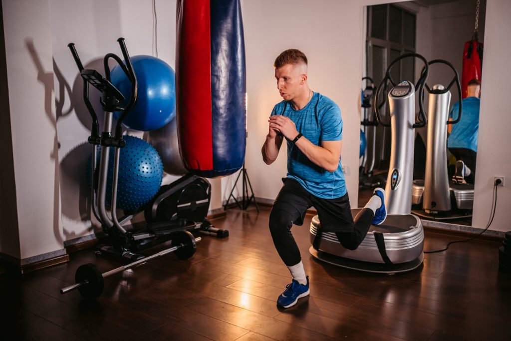 male PT performing bulgarian split squat