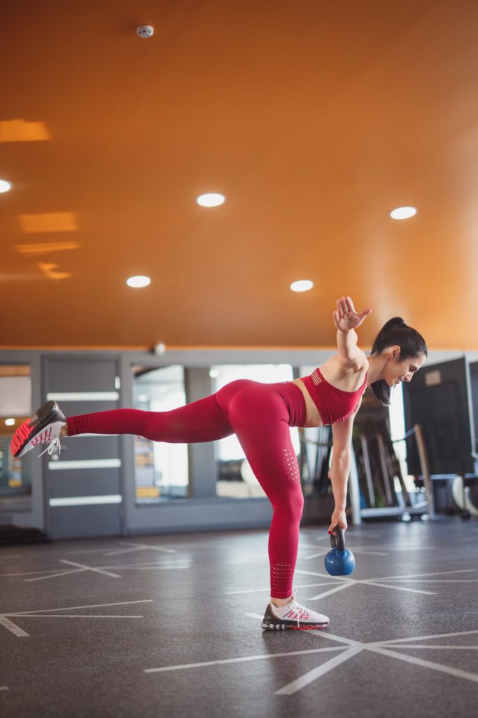 woman performing a single leg deadlift with a kettlebell