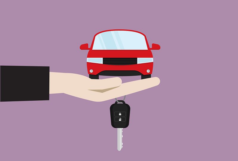 Hand holds a car and a car key