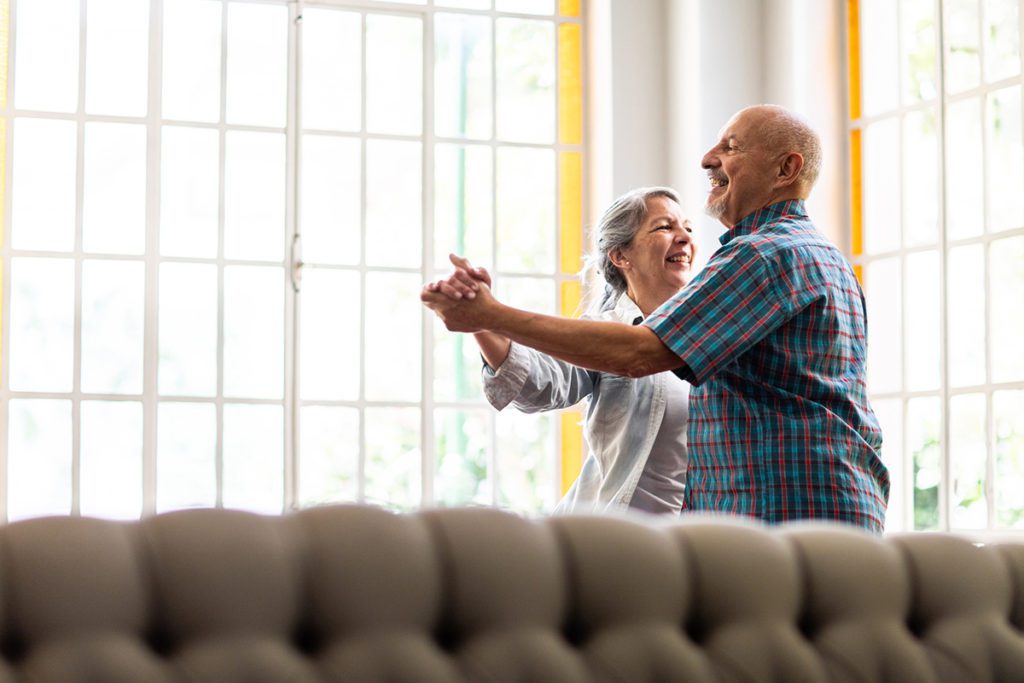 A senior couple dancing in their living room