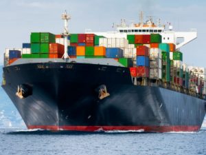 Container ship, heavily loaded, at sea.