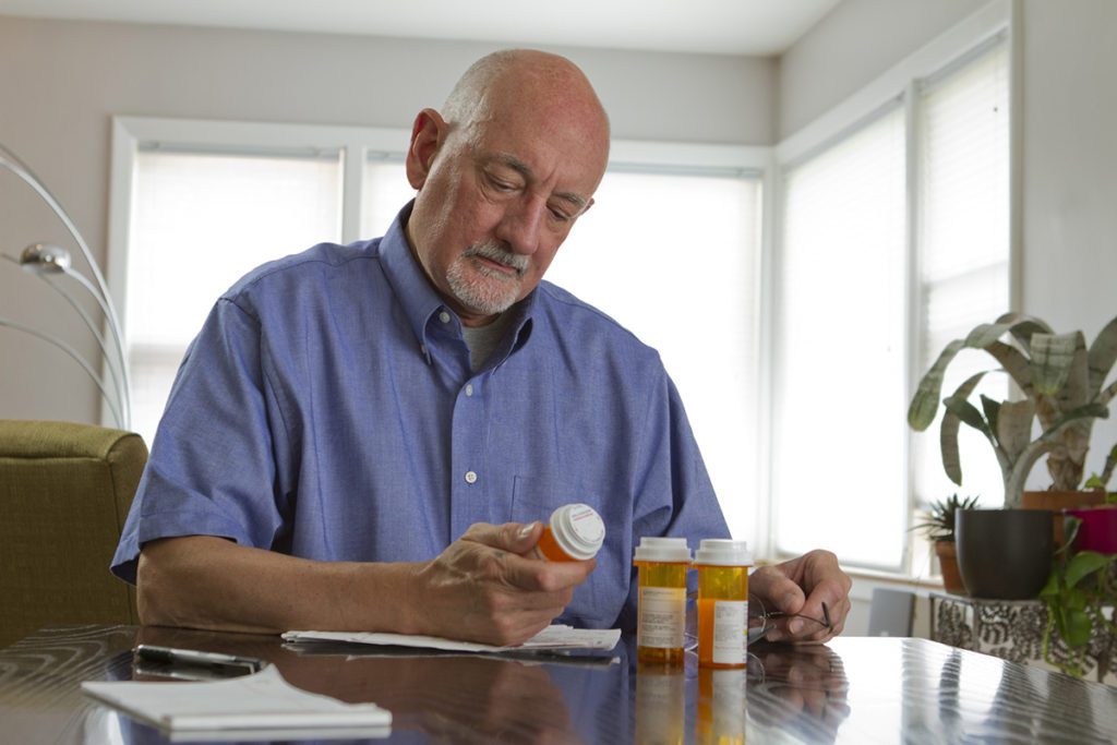 A man reads the label on his prescription bottle