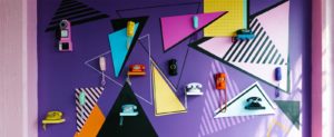 Image of a colourful wall consisting of geometric shapes and retro telephones. 
