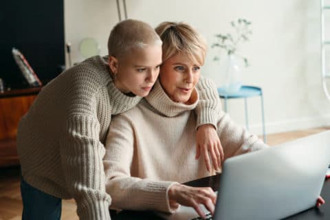 Mother And Adult Daughter Using Electronic Device