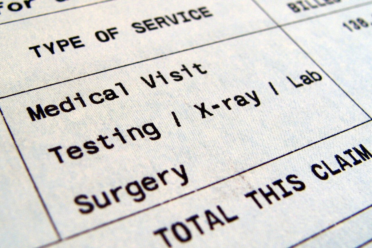 A photo shows a medical bill for a medical visit, testing, x-ray, lab and surgery.