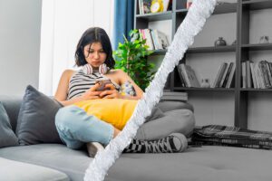 A troubled young woman looks at her phone.