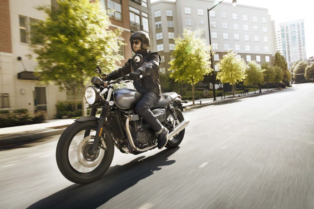 Person riding Triumph Street Twin down road