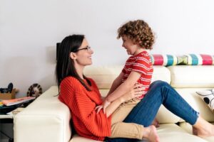 child sitting on mom's lap on a beige colored couch