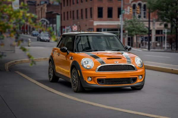 Orange Mini Cooper R56 driving down road