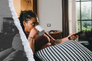 A woman sips coffee while watching the news