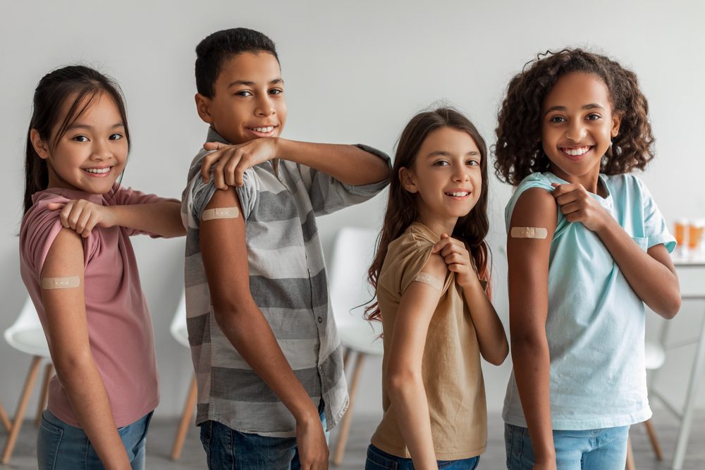 Cheerful Vaccinated Kids Showing Arms after Vaccines