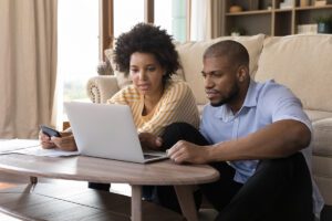 A young couple shops for insurance on their laptop