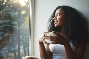 Happy woman looking out of her window