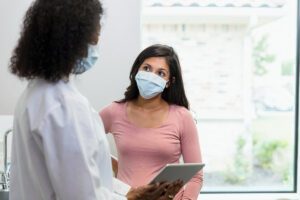 A woman listens to her doctor explain something.