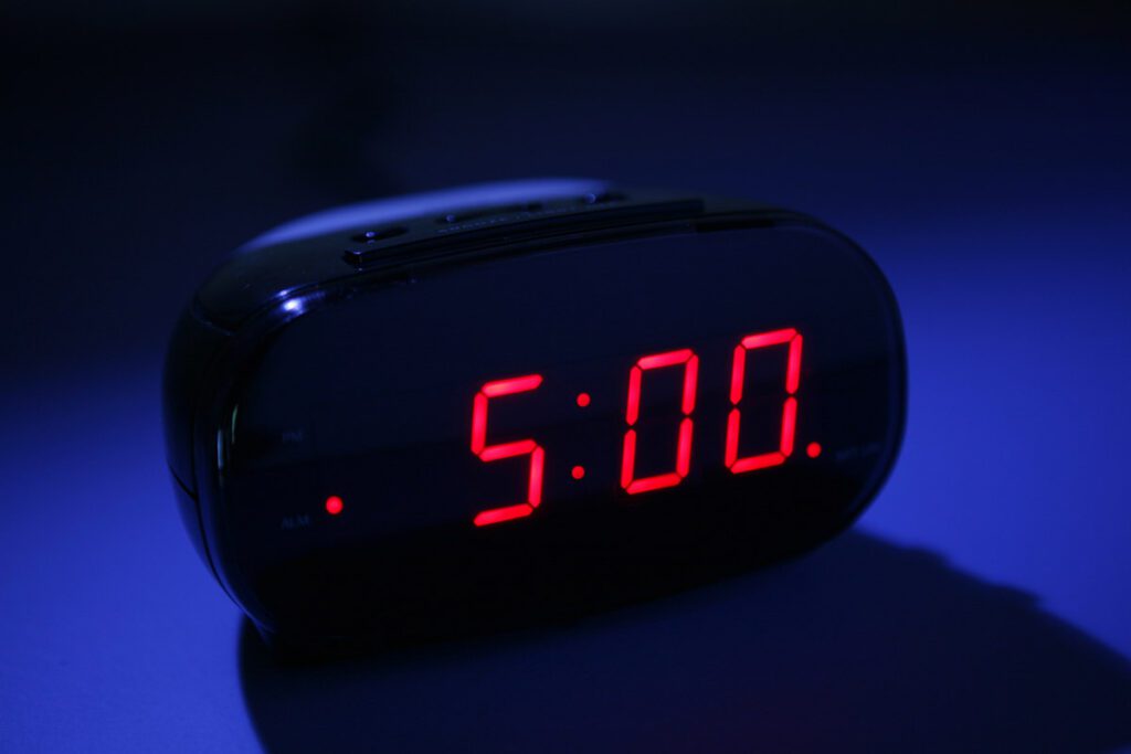 A digital clock reading five a.m.