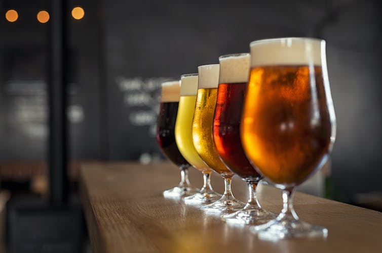 Four beer glasses lined up on a table