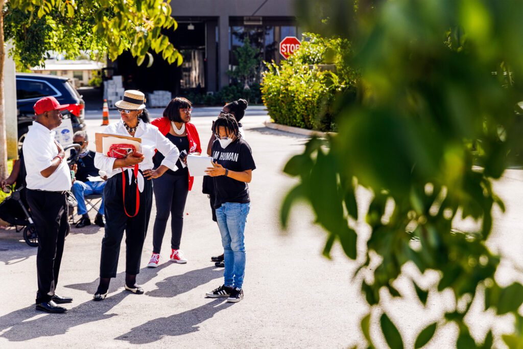 A photo shows a group of people gathered outside, holding petitions, asking passersby to sign them.