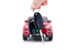 Dangling car key in front of a car