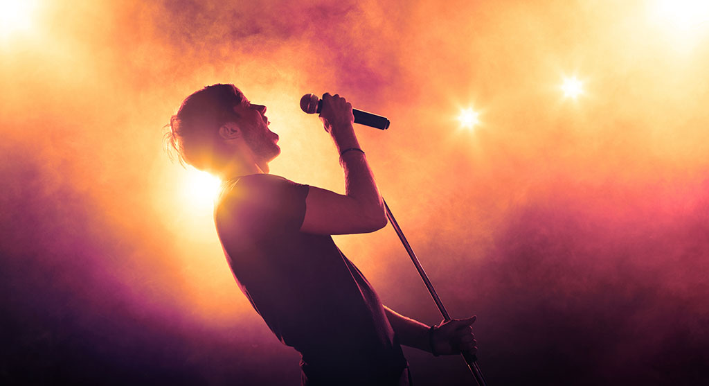 Singer holding a microphone stand and performing on stage