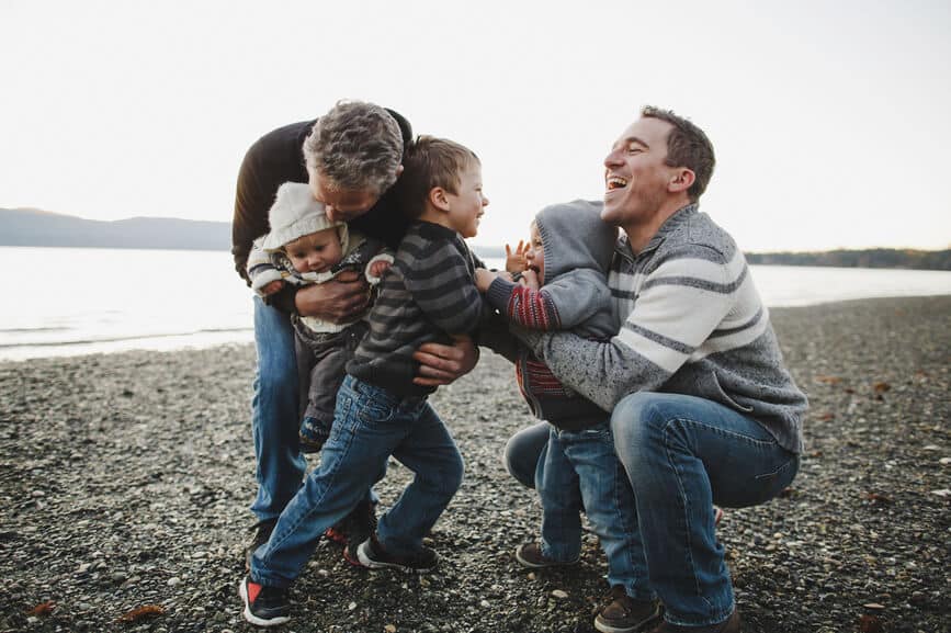 Multigenerational Family At Beach Having Fun Together Wrestling