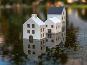 Three white house figurines submerged in water.