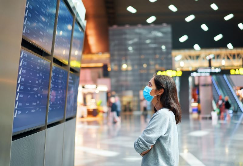 Woman in an airport checking out flight cancellations on the board