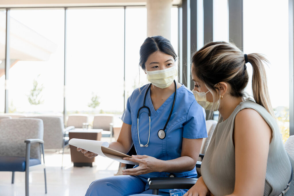 Female nurse asks young woman questions for record