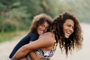 Happy Mom And Daughter In The Beach. Stock photo of cheerful latin woman and her young daughter playing in the beach in Costa Rica.