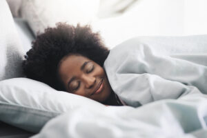 A young woman sleeps contentedly, with a smile on her face