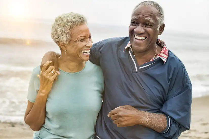 Older couple smiling on the beach