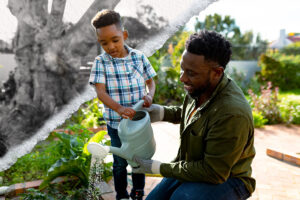 A father and young son water their garden together.