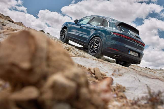 A poorly composed photo of a blue 2024 Porsche Cayenne, rear three-quarter view.