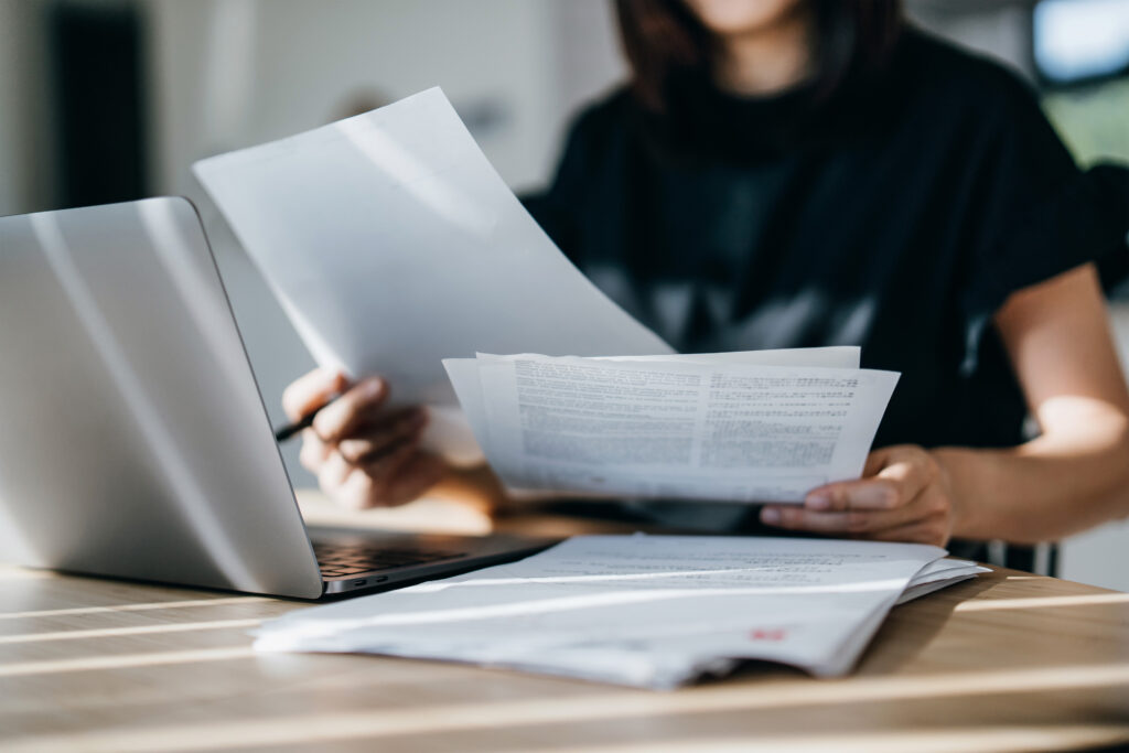 A photo of a woman preparing paperwork at her desk.